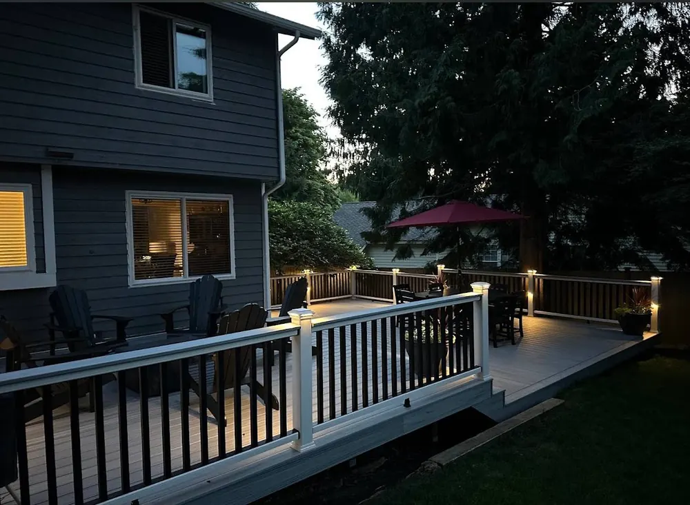 Deck with white railings and post lights at dusk