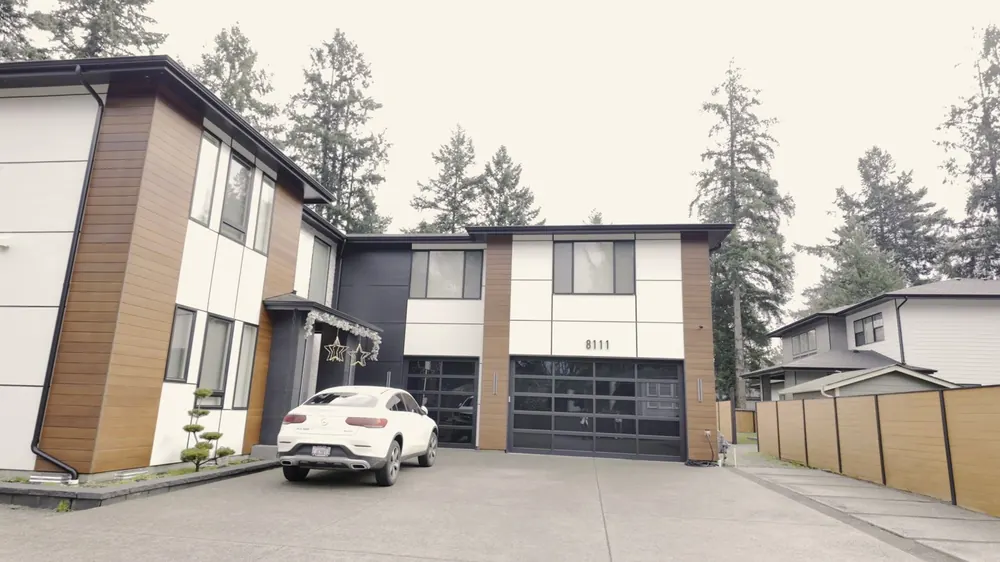 Two-story house front with wood-look and dark panel siding